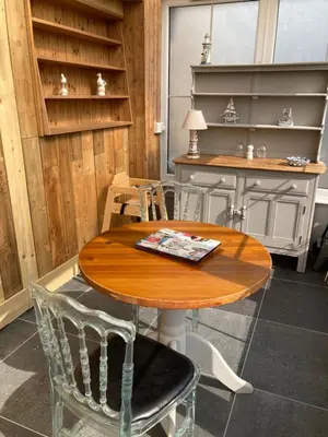 a wooden table and chairs in a room at Bossiney Lodge Apartment in Tintagel