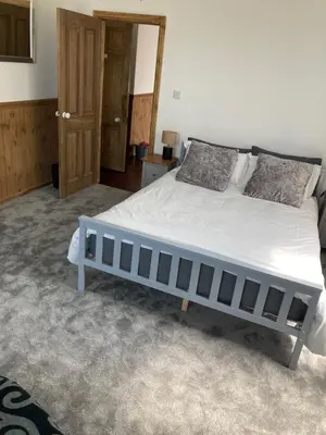 a bedroom with a large bed in a room at Bossiney Lodge Apartment in Tintagel