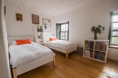 a bedroom with two beds and a book shelf at 5 Star Large Farmhouse Near The Beach With Hot Tub & Sauna - Porth, Near Newquay in Saint Columb Minor