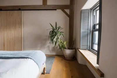 a bedroom with a bed and a potted plant at 5 Star Large Farmhouse Near The Beach With Hot Tub & Sauna - Porth, Near Newquay in Saint Columb Minor