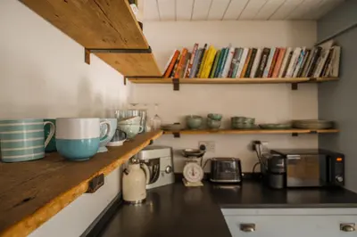 a kitchen with a counter top with books at 5 Star Large Farmhouse Near The Beach With Hot Tub & Sauna - Porth, Near Newquay in Saint Columb Minor