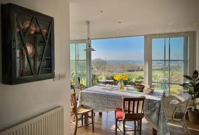 a dining room with a table and a large window at Old Chapel House in Tintagel