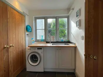 a kitchen with a sink and a washing machine at Old Chapel House in Tintagel