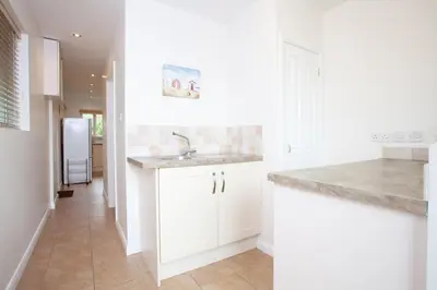 a kitchen with white cabinets and a sink at Creek View in Feock