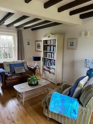 a living room with a couch and a table at Trevigue Cottage in Bude