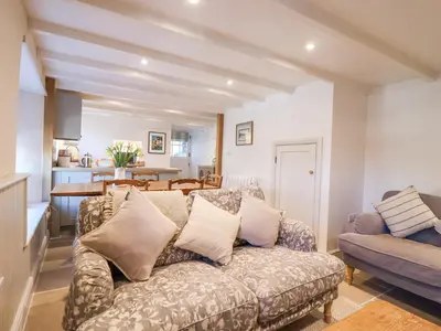 a living room with a couch and a table at Harbour View in Looe