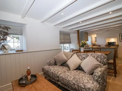 a living room with a couch and a table at Harbour View in Looe