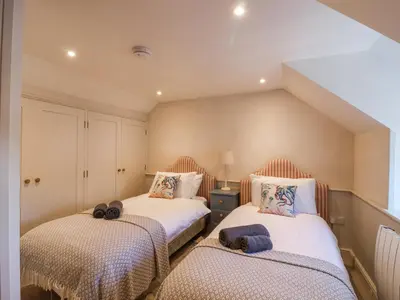 a bedroom with two beds with towels on them at Harbour View in Looe