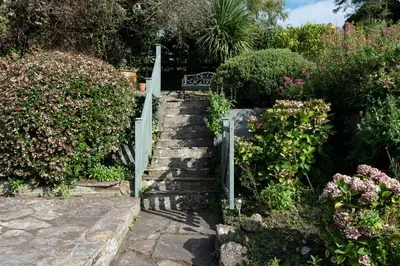 a set of stairs in a garden with flowers at Honeysuckle Cottage in Saint Minver