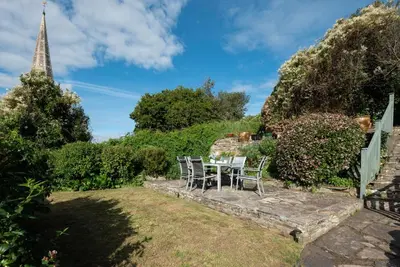 a table and chairs in the garden of a house at Honeysuckle Cottage in Saint Minver