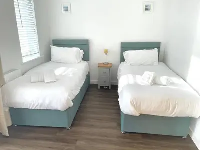 a bedroom with two beds with white sheets at Hayle - 2 bedrooms house with EV parking, 4 beds in Hayle