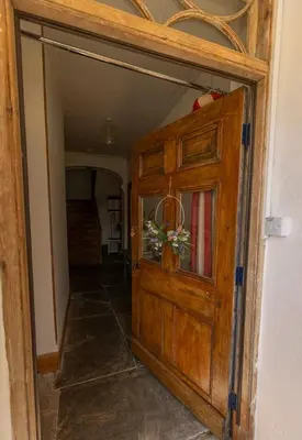 a hallway with a wooden door in a house at The perfect bolt hole in Quethiock