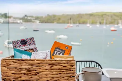 a basket of food and books on a table with a harbor at 2 Bed in Polruan oc-w31943 in Fowey