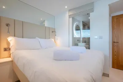 a white bed with white pillows in a bedroom at 2 Bed in Polruan oc-w31943 in Fowey
