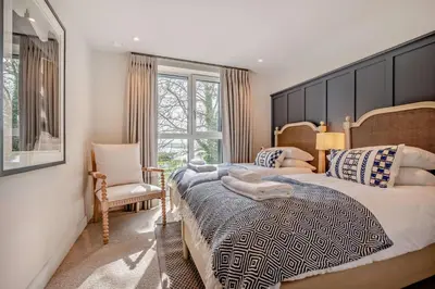 a bedroom with a large bed and a chair at 2 Bed in Padstow oc-h29015 in Padstow