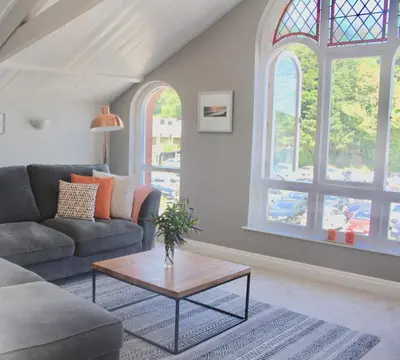 a living room with a couch and a table at St Monica's in Fowey