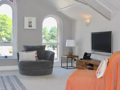 a living room with a couch and a television at St Monica's in Fowey
