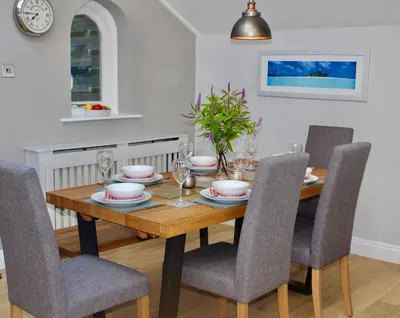 a dining room with a wooden table and chairs at St Monica's in Fowey