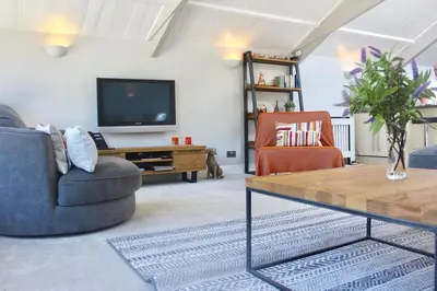 a living room with two chairs and a television at St Monica's in Fowey