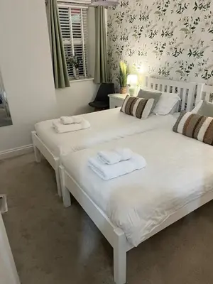 two beds in a bedroom with towels on them at St Monica's in Fowey