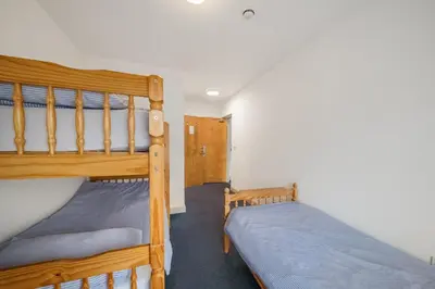 two bunk beds in a small room withthritisthritisthritisthritisthritisthritisthritisthritis at Breakwater Hostel in Newquay