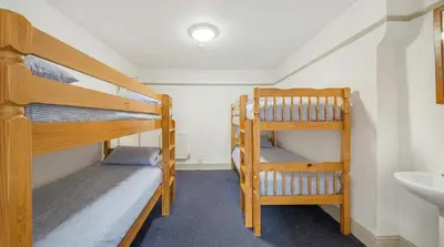 two bunk beds in a room with a sink at Breakwater Hostel in Newquay