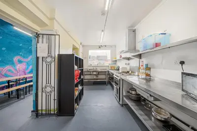 a large kitchen with stainless steel counters and a large window at Breakwater Hostel in Newquay