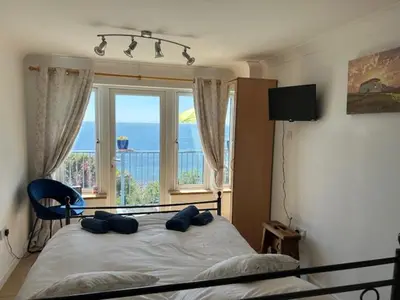 a bedroom with a bed with a view of the ocean at Ocean View at Kenwyn in Torpoint