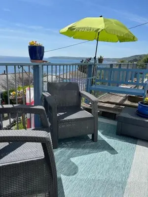 a patio with a chair and an umbrella at Ocean View at Kenwyn in Torpoint
