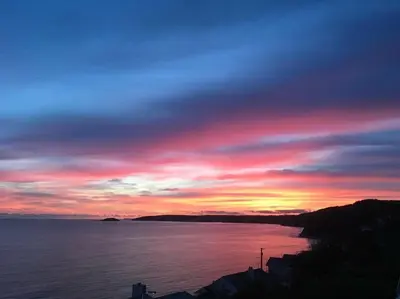 a sunset over a body of water with at Ocean View at Kenwyn in Torpoint