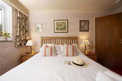 a bedroom with a bed with a hat on it at Little Rabbit Hill in Polzeath