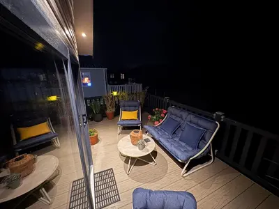 a balcony with a couch and chairs and a table at Serenity in Saint Erth