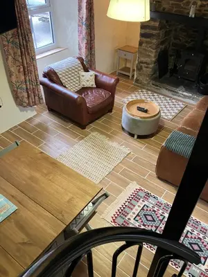 a living room with a couch and a chair and a fireplace at Knockers Retreat, St Agnes in St. Agnes