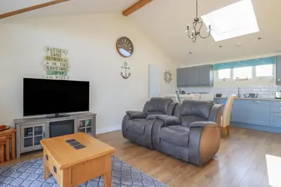 a living room with a couch and a flat screen tv at Lodge 18 in Padstow