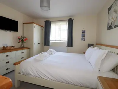 a bedroom with a white bed and a window at Lodge 18 in Padstow