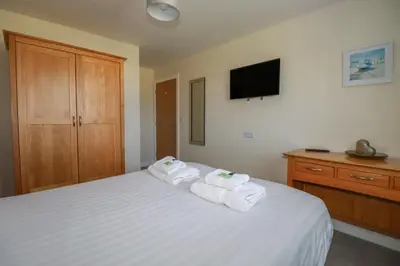 a bedroom with a white bed with towels on it at Lodge 18 in Padstow