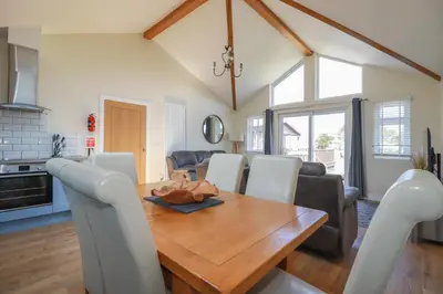 a kitchen and dining room with a wooden table and chairs at Lodge 18 in Padstow