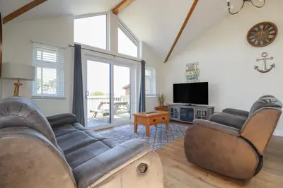 a living room with two couches and a tv at Lodge 18 in Padstow