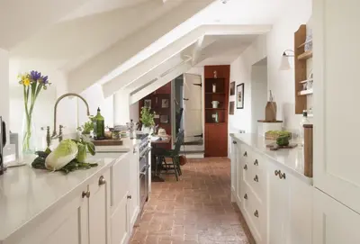 a large kitchen with white cabinets and a kitchen island at Besloe in Delabole