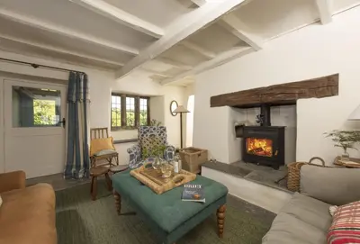 a living room with a couch and a fireplace at Besloe in Delabole