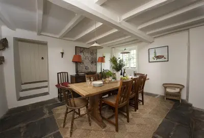 a dining room with a wooden table and chairs at Besloe in Delabole