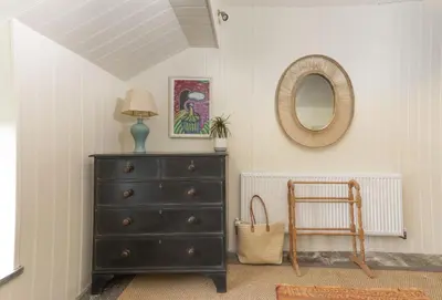 a dresser with a lamp and a mirror in a room at Besloe in Delabole