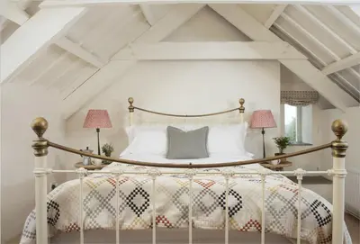 a bedroom with a canopy bed with two lamps at Besloe in Delabole