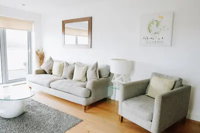a living room with a couch and a chair at Azure 7 Apartment in Newquay