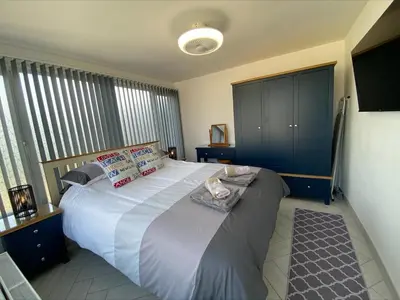 a bedroom with a large white bed with pillows at Apartment Close To Porth Beach in Saint Columb Minor