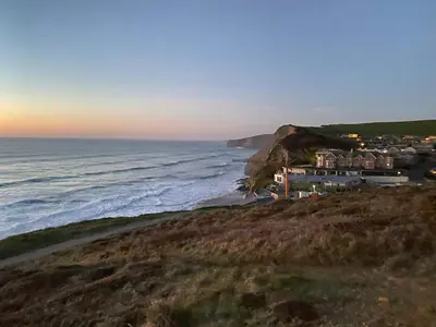 a house on a cliff next to the ocean at Apartment Close To Porth Beach in Saint Columb Minor