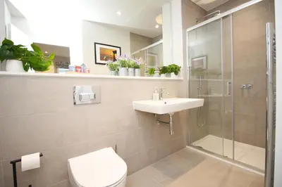 a bathroom with a shower and a toilet and a sink at Secluded two bedroom apartment in Padstow