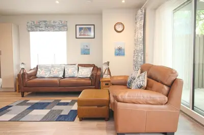 a living room with a couch and a chair at Secluded two bedroom apartment in Padstow