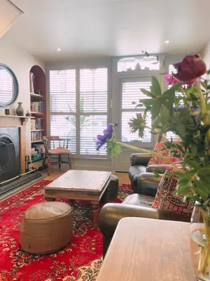 a living room with a couch and a table at Old Bookshop - Unique house in central St Ives with outdoor space in St Ives
