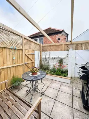 a patio with a table and a bench and a fence at Old Bookshop - Unique house in central St Ives with outdoor space in St Ives